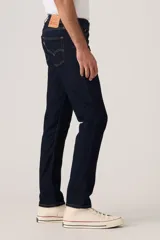 Jean de corte slim fit en color azul oscuro, con diseño clásico de cinco bolsillos, cierre de cremallera y botón metálico.