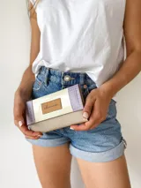 Billetera de cuero color crema, lila y beige con cierre de broche y monedero externo.