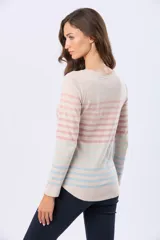 Remera de manga larga con cuello redondo y cierre frontal parcial con botones. Presenta un diseño de rayas horizontales en tonos pastel sobre una base beige, con aberturas laterales en el ruedo.