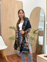 Bufanda larga con estampado de cuadros y flores en tonos marrón, azul y beige, con flecos en los extremos.