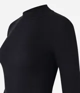 Remera blanca de algodón con cuello alto y mangas largas. Diseño ajustado al cuerpo y textura acanalada.