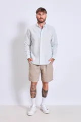 Camisa de corte regular con diseño de rayas verticales finas en tonos claros, cuello clásico y mangas largas con puños abotonados.