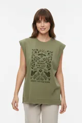 Musculosa color crudo con estampado frontal de paisaje montañoso y texto "EXPLORING Outlands", corte holgado y aberturas laterales en el ruedo.