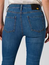 Jeans de corte ajustado en denim color azul medio, con diseño clásico de cinco bolsillos, cierre de cremallera y costuras reforzadas.