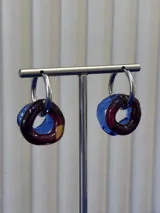 Aros de argolla en plata 925 con dijes circulares de vidrio soplado en tonos azul y bordó.