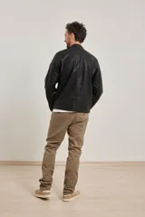 Campera de cuero ecológico color negro, con cuello mao y cierre frontal con cremallera metálica al tono.