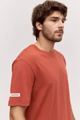Remera blanca de algodón, de corte holgado y mangas cortas, con pequeño estampado azul en el pecho.