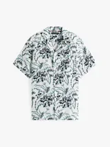 Camisa de manga corta con cuello solapa y estampado floral en tonos negro, blanco y verde.