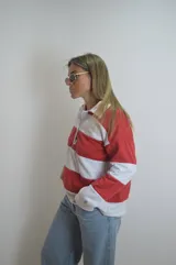 Sweater de algodón a rayas horizontales rojas y blancas, con cuello polo y cierre parcial con botones.