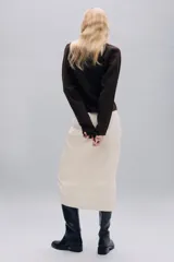 Chaqueta de punto con escote en pico y manga larga. Presenta cierre frontal con botones y costuras verticales decorativas en el frente.