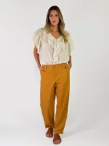 Pantalon de lino color mostaza con bolsillos laterales, tiro medio y corte recto.