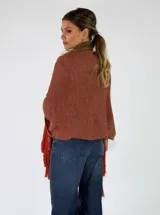 Pashmina de punto color beige con bordados sutiles y flecos largos en los bordes.