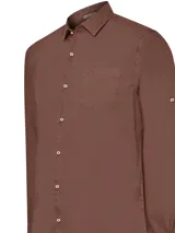 Camisa de manga larga Leeds confeccionada en popelina de algodón orgánico. Presenta cuello italiano, cierre frontal con botones, bolsillo en el pecho con logo bordado y mangas ajustables con botón. Diseño con ruedo redondeado.