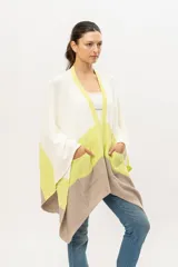 Ruana tejida de punto en algodón, con diseño color block en blanco, verde lima y beige. Tiene bolsillos laterales.
