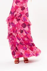 Vestido largo fucsia con estampado abstracto, cuello halter con abertura en forma de lágrima y volados en la falda.