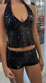 Short de tiro bajo confeccionado en tela con lentejuelas negras, de corte ajustado.