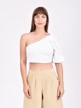 Top blanco con un solo hombro, manga corta abullonada y detalle de calado.