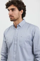 Camisa celeste de algodón con cuello abotonado, manga larga con puños abotonados y bolsillo en el pecho. Corte clásico.