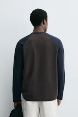 Camiseta de corte relajado con cuello redondo y mangas largas tipo raglán en contraste de color.