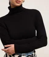 Suéter de punto color borgoña, con cuello alto estructurado y mangas largas.