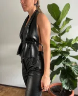 Top negro sin mangas, con escote halter y espalda descubierta.