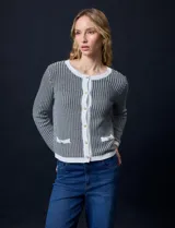 Cardigan de tejido tweed celeste y blanco, con escote redondo, cierre frontal con botones metálicos dorados y bolsillos simulados en el frente.