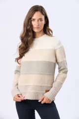 Buzo tejido de abrigo con cuello redondo y diseño a rayas horizontales en tonos gris, rosado, bordó y tostado. Cuenta con un pequeño aplique de cuero sintético con grabado en el borde inferior.