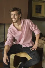 Camisa de manga larga a rayas verticales rojas y blancas, con cuello clásico y corte holgado.