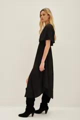 Vestido midi de color negro con escote en V, mangas cortas y cintura elástica. Presenta un diseño fluido con una abertura frontal central en la falda.