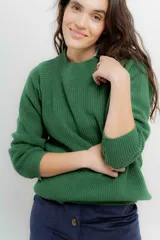 Sweater de punto en color crema con rayas horizontales en tono dorado. Presenta un diseño de cuello redondo con una solapa lateral decorada con botones metálicos dorados y corte holgado.