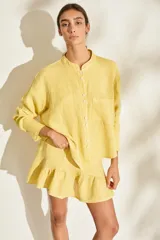 Camisa de lino italiano color amarillo, con cuello mao, cierre frontal de botones, bolsillo aplicado en el pecho y manga larga.