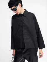 Camisa negra de algodón con botones en la parte delantera y cortes geométricos.