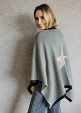 Ruana tejida en algodón con diseño de estrella grande en la espalda y bordes en contraste. Presenta un corte amplio y fluido, ideal para usar como capa sobre otras prendas.