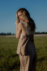 Conjunto de dos piezas compuesto por un top sin mangas con diseño bicolor en blanco y negro y detalle bordado frontal, y un pantalón de corte recto y ancho en color negro con bolsillos laterales y cintura ajustable.