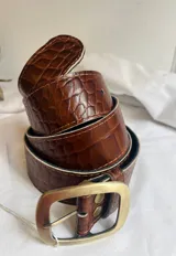Cinto de cuero con hebilla metálica dorada.