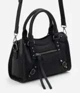 Cartera satchel Satinato de color negro, confeccionada en poliuretano. Cuenta con asas de mano fijas, correa larga removible, bolsillos frontales con cierre, tachas metálicas decorativas y tiras colgantes.