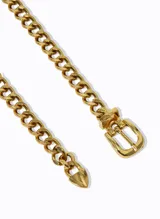Cinturón dorado de cadena gruesa con eslabones entrelazados, hebilla metálica y detalle de cadena larga con punta.
