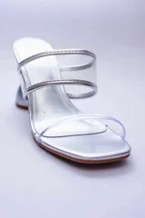 Sandalias plateadas con taco de forma geométrica y tiras transparentes.