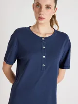 Vestido largo azul marino de corte recto y silueta relajada, con escote redondo, mangas cortas y cierre frontal parcial de botones. Cuenta con aberturas laterales en el bajo.