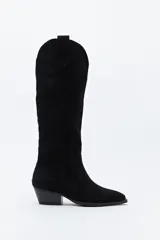 Bota texana de caña alta confeccionada en gamuza negra, con diseño de estilo western, costuras decorativas, tirador superior y taco bajo levemente inclinado.