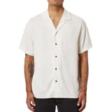Camisa de manga corta color blanco hueso, con cuello solapa y cierre frontal con botones marrones.