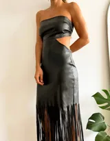 Vestido midi negro de cuerina, corte recto, sin mangas, escote recto, con aberturas laterales en la cintura y flecos en el ruedo.