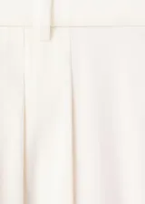 Pantalón de corte recto y tiro regular, color blanco, con bolsillos laterales y pinzas en la parte delantera.