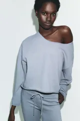Sudadera de algodón con cuello barco y mangas largas acampanadas con terminación evasé. Presenta un diseño minimalista con bajo recto y bordes sin costuras visibles.