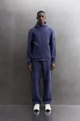 Campera canguro de Zara Athleticz, modelo relaxed fit, confeccionada en tejido técnico compacto elástico con mezcla de algodón en color azul marino. Cuenta con cuello subido con capucha, manga larga con bolsillo lateral con cierre, bolsillos frontales con cierre y acabado termofijado, cierre frontal de doble dirección y logo estampado en el bajo.