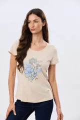 Remera beige de manga corta con cuello redondo, confeccionada en algodón con un diseño delantero que combina estampa floral y detalles bordados.