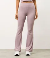 Pantalón deportivo Get Over modelo flare, confeccionado en microfibra acanalada de color lila. Presenta un corte ajustado en caderas y muslos con apertura acampanada desde la rodilla.