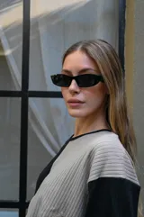 Lentes de sol con armazón rectangular de estilo moderno y minimalista, en color negro con cristales oscuros.