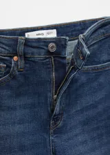 Jeans de corte skinny y tiro alto, confeccionados en tejido denim de algodón con elastano. Presentan diseño clásico de cinco bolsillos, cierre de cremallera con botón y trabillas en la cintura.