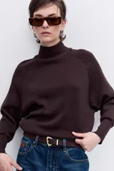 Sweater de punto negro con cuello alto y mangas largas con corte raglán.
